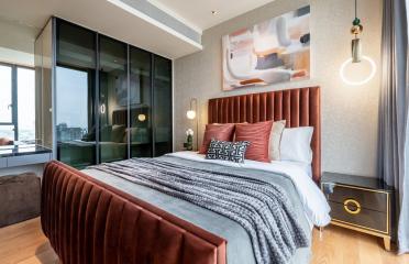 Modern bedroom with queen-sized bed, artistic wall painting, and balcony access