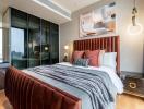 Modern bedroom with queen-sized bed, artistic wall painting, and balcony access