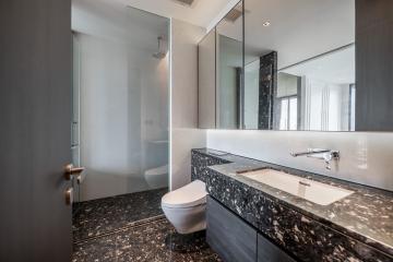 Modern bathroom with marble countertops and glass shower cabin
