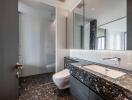 Modern bathroom with marble countertops and glass shower cabin
