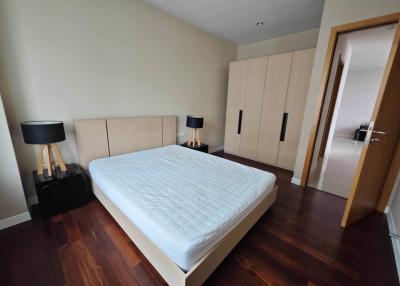 Spacious bedroom with hardwood flooring and large wardrobe