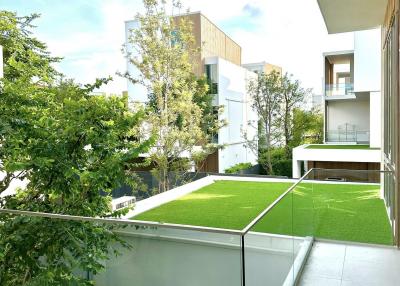 Modern balcony with glass railing overlooking a garden