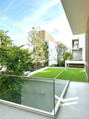 Modern balcony with glass railing overlooking a garden