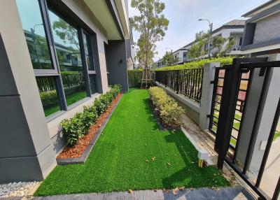 Modern house exterior with well-manicured artificial lawn and elegant entrance