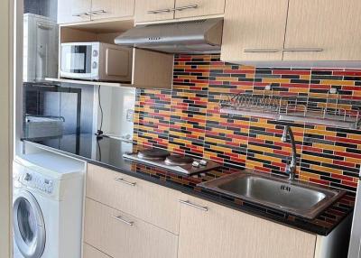 Modern kitchen with stainless steel appliances and bold backsplash