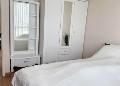 Bright bedroom with large bed and white wardrobe