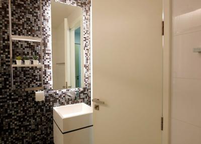 Modern bathroom with mosaic tile walls and glass shower door