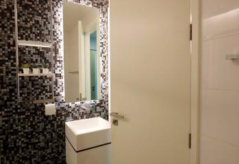 Modern bathroom with mosaic tile walls and glass shower door