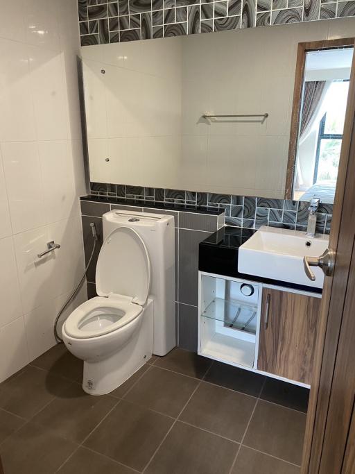 Modern bathroom with wooden vanity and gray tiles