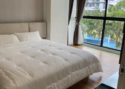 Spacious bedroom with large bed and pool view