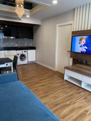 Modern mixed-use space with kitchen appliances, in-unit laundry, and entertainment area