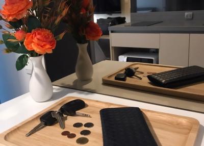 Modern kitchen interior with flowers and wooden tray containing personal items