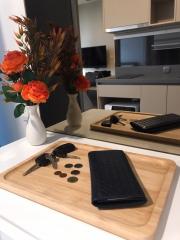 Modern kitchen interior with flowers and wooden tray containing personal items