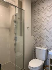 Modern bathroom with a glass shower enclosure and patterned wall tiles