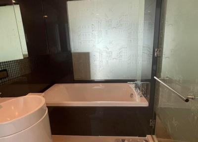 Modern bathroom interior with a bathtub, toilet, and glass shower