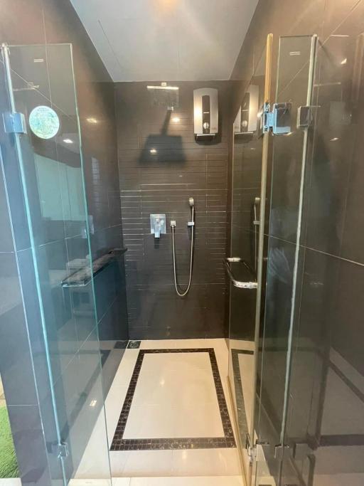 Modern bathroom interior with glass shower and dark tiles