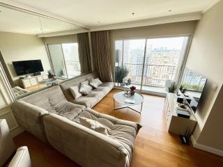 Spacious and well-lit living room with large windows and city view