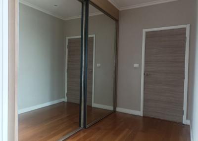Empty bedroom with wooden floor and mirrored closet doors