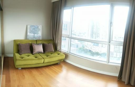 Bright living room with large window views and a green sofa