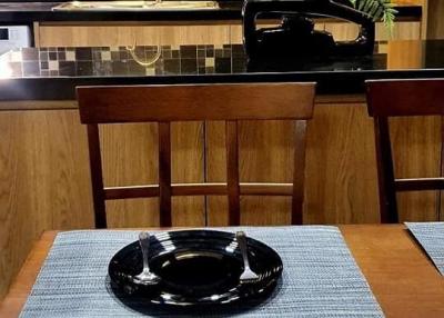 Modern kitchen with wooden dining table and stylish black tile backsplash
