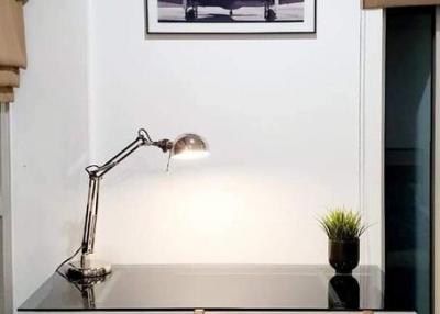 Home office area with a modern desk, stylish lamp, and framed wall art
