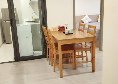 Modern dining area with wooden table and chairs, open concept layout with kitchen visibility