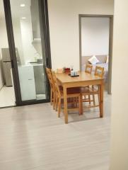 Modern dining area with wooden table and chairs, open concept layout with kitchen visibility