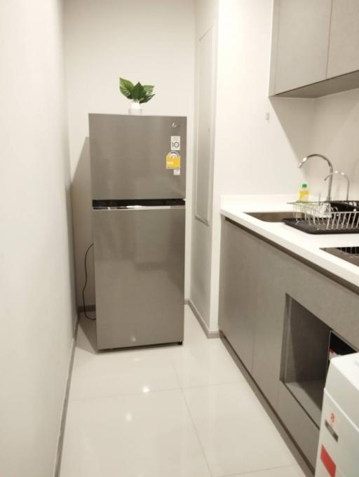 Modern kitchen with stainless steel refrigerator and white cabinets