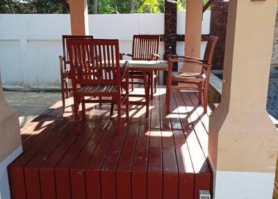 Wooden patio furniture set under a covered outdoor area