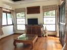 Spacious living room with hardwood floors and natural light