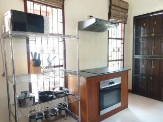 Modern kitchen with stainless steel shelving unit and built-in oven