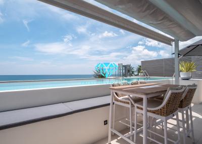 Spacious oceanfront balcony with dining area and infinity pool