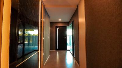 Modern hallway in residential home with dark tones and recessed lighting