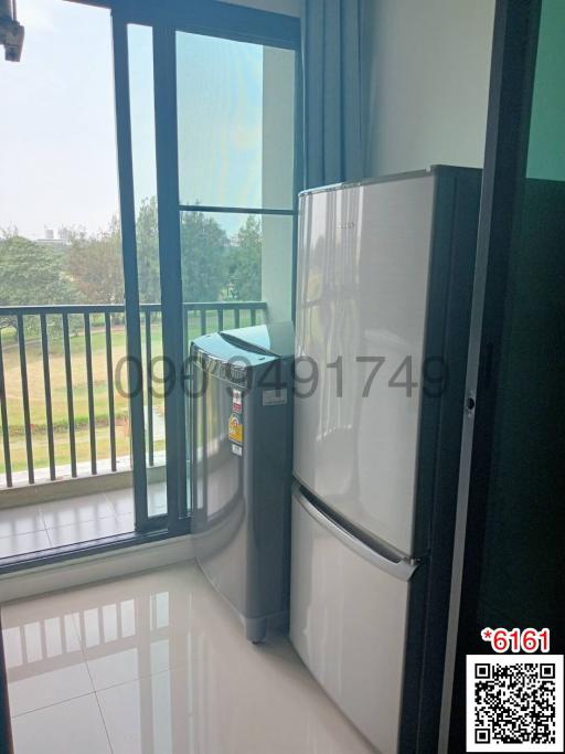 Balcony with refrigerator and outdoor view through large windows