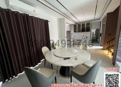 Modern dining area with an open kitchen in the background