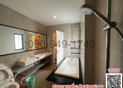 Spacious modern bathroom with dual vanities and separate bath and shower areas