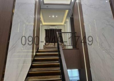 Elegant marble staircase with modern lighting fixtures leading to upper level