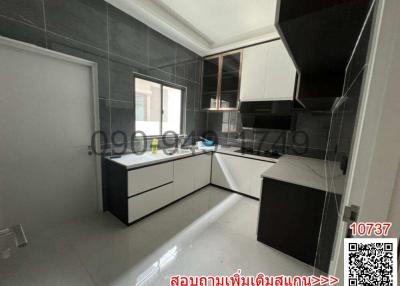 Modern kitchen with white cabinets and dark backsplash