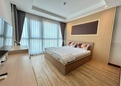 Modern bedroom with large windows and wooden flooring
