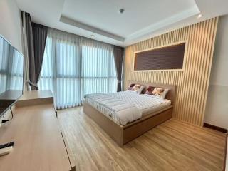 Modern bedroom with large windows and wooden flooring