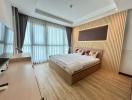 Modern bedroom with large windows and wooden flooring