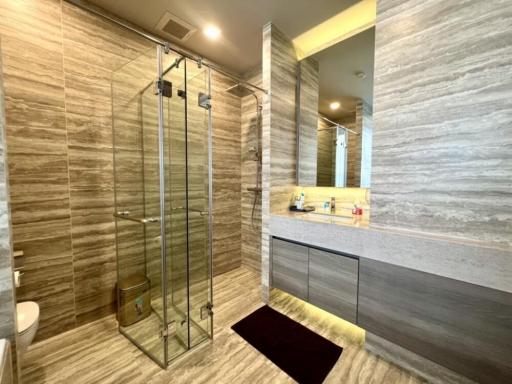 Modern bathroom with glass-enclosed shower and marble tiles