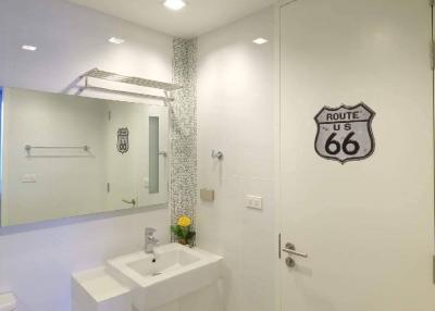 Modern bathroom with white vanity and Route 66 wall decoration