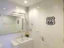 Modern bathroom with white vanity and Route 66 wall decoration