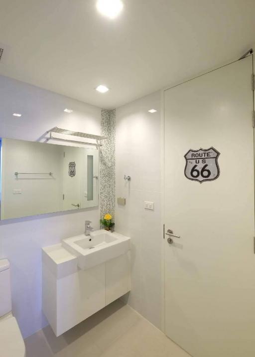 Modern bathroom with white vanity and Route 66 wall decoration