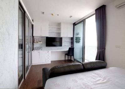 Modern bedroom with an integrated kitchenette and balcony access