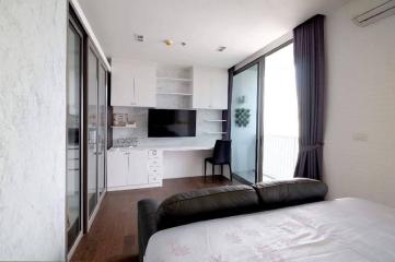 Modern bedroom with an integrated kitchenette and balcony access