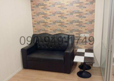 Cozy living room with dark sofa and decorative brick wall panel