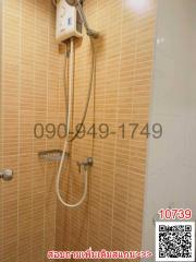 Wall-mounted electric shower unit in a tiled bathroom