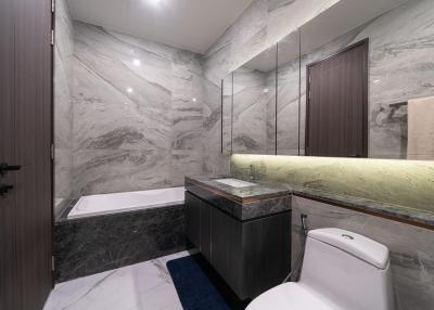 Modern bathroom with marble tiling and bathtub